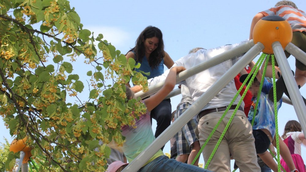 Filiz Keküllüoğlu klettert mit kleinen und großen Menschen auf einem Klettergerüst.